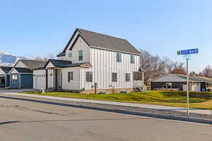 View of front facade featuring cooling unit, a garage, a mountain view, and a front lawn