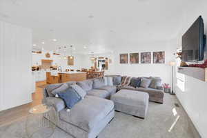 Living room with light wood-type flooring and sink