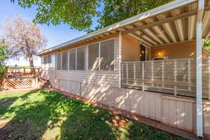 View of home's exterior featuring a lawn and a deck