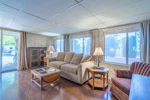 Living room featuring hardwood / wood-style flooring, plenty of natural light, and a paneled ceiling