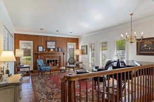 Living room featuring a notable chandelier, crown molding, and parquet floors