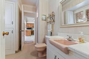 Bathroom featuring vanity, crown molding, and toilet