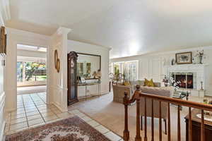 Tiled living room with a fireplace and crown molding