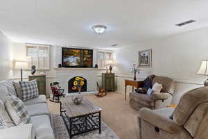 Carpeted living room featuring a brick fireplace