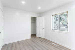 Unfurnished bedroom featuring a closet and light hardwood / wood-style floors