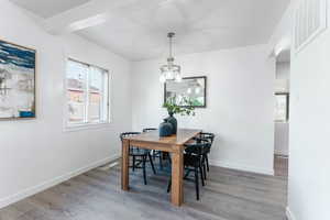 Dining area with hardwood / wood-style flooring and a chandelier