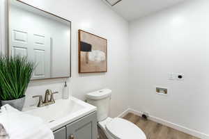 Bathroom featuring toilet, vanity, and wood-type flooring