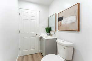 Bathroom featuring hardwood / wood-style floors, vanity, and toilet