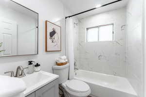 Full bathroom featuring shower / bath combination with curtain, vanity, and toilet