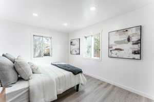 Bedroom with light wood-type flooring and multiple windows