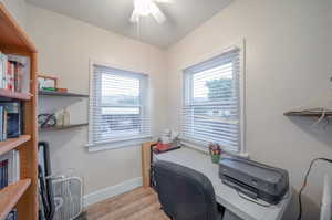 Office with ceiling fan, light wood-type flooring, and a healthy amount of sunlight