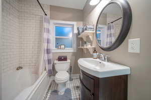 Full bathroom with vanity, tile patterned flooring, toilet, and shower / bath combo