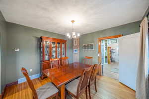 Dining space with light wood-type flooring, plenty of natural light, and a chandelier