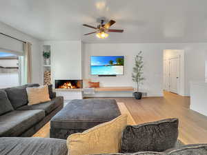 Living room featuring ceiling fan and light wood-type flooring