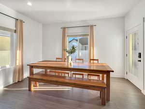 Dining room with a textured ceiling and dark wood-type flooring