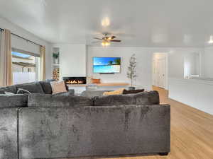 Living room featuring ceiling fan, light hardwood / wood-style floors, and a textured ceiling