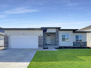 View of front of house with a garage and a front lawn