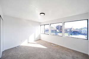 Unfurnished room featuring light carpet and a textured ceiling