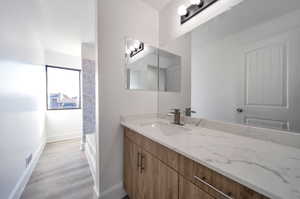 Bathroom with a bathtub, hardwood / wood-style flooring, and vanity