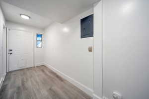 Interior space featuring electric panel and light hardwood / wood-style floors