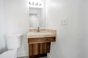 Bathroom with wood-type flooring, vanity, and toilet