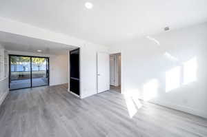 Unfurnished bedroom featuring access to outside and light wood-type flooring