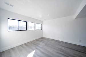 Empty room with hardwood / wood-style floors