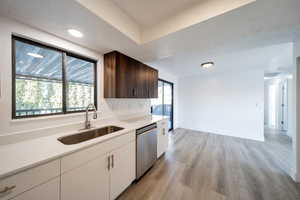 Kitchen featuring sink, a wealth of natural light, stainless steel dishwasher, and white cabinets