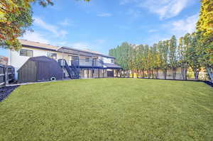 View of yard with a deck and a storage shed