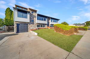 View of front of house with a garage and a front lawn