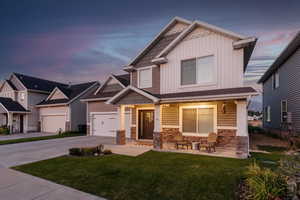 Craftsman inspired home featuring a garage, a porch, and a yard