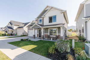 Craftsman inspired home featuring a front lawn and a garage