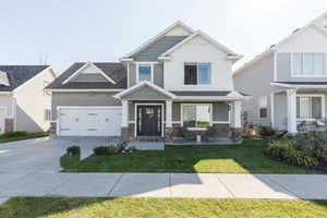 Craftsman inspired home featuring a front lawn and covered porch