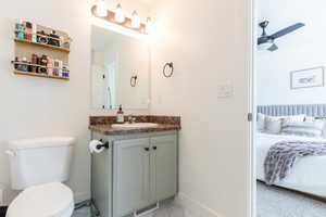 Bathroom with ceiling fan, vanity, and toilet