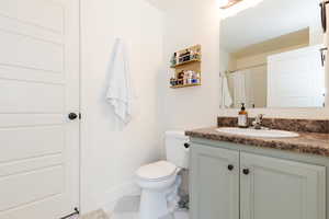 Bathroom featuring tile patterned floors, vanity, and toilet