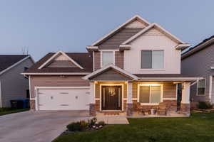 Craftsman house featuring a garage, a front lawn, and covered porch