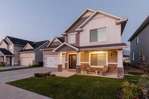 Craftsman house with a garage, a front lawn, and covered porch