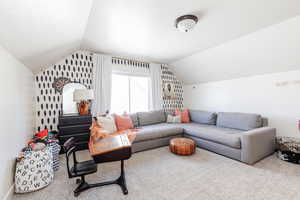 Living room featuring vaulted ceiling and carpet flooring