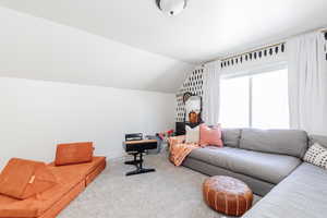 Living room with light colored carpet and lofted ceiling