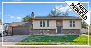 View of front of property featuring a front yard and a garage