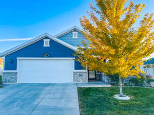 View of front facade featuring a garage and a front lawn