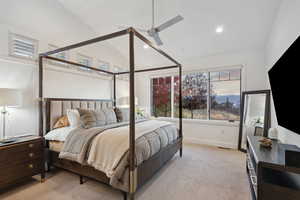 Bedroom with ceiling fan, lofted ceiling, and light carpet