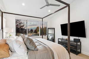 Carpeted bedroom featuring vaulted ceiling and ceiling fan