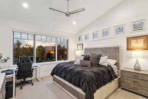 Bedroom featuring lofted ceiling, ceiling fan, and light colored carpet