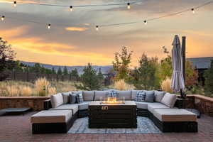 Patio terrace at dusk featuring a mountain view and an outdoor living space with a fire pit