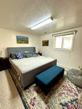 Bedroom with carpet and a textured ceiling