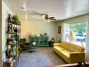 Sitting room featuring carpet floors, a textured ceiling, and ceiling fan