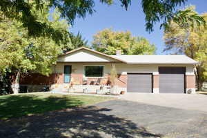 Single story home with a garage, a porch, and a front yard