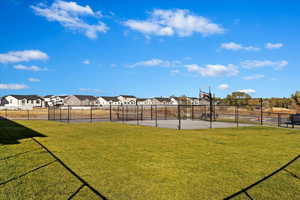 View of sport court featuring a yard