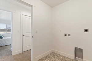 Laundry area with hookup for a washing machine, light colored carpet, and electric dryer hookup